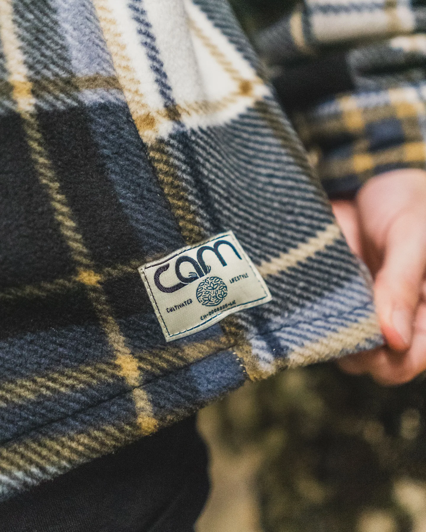 Close view of a CAM woven label on plaid outerwear